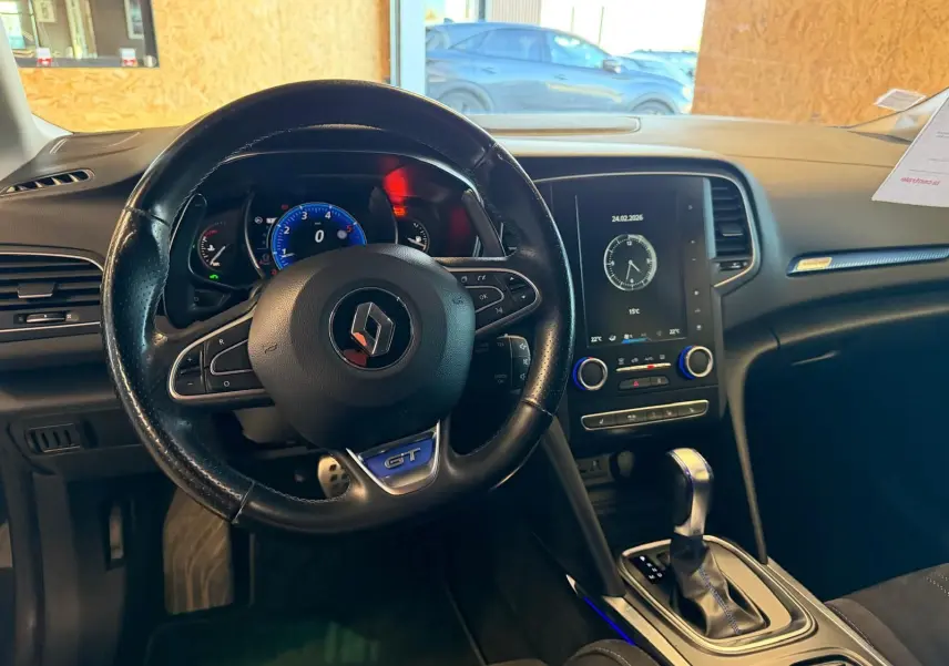 Vue intérieure centrée sur le volant GT et la console centrale avec écran tactile du Renault Mégane Break gris.