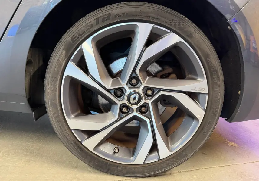 Gros plan sur la roue avant droite grise de la Renault Mégane Break GT 1.6 DCI 165 EDC avec jante alliage et logo GT visible.