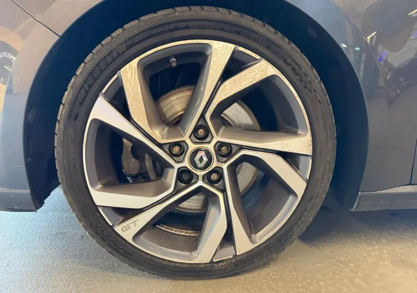 Gros plan sur la jante alliage GT de la Renault Mégane Break gris, mettant en valeur le logo Renault au centre.