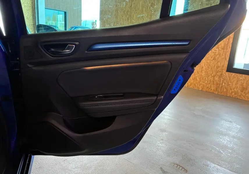 Vue intérieure de la porte arrière gauche bleu foncé de la Renault Mégane 1.7 BlueDCI GT Line avec garniture noire et insert décoratif bleu.