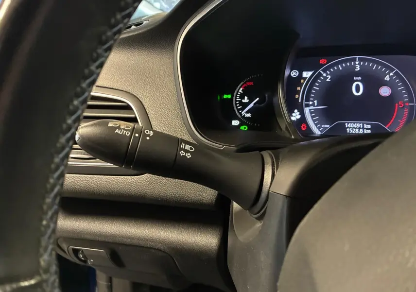 Vue rapprochée du commodo d’éclairage et du tableau de bord numérique d’une Renault Mégane bleu 2019.