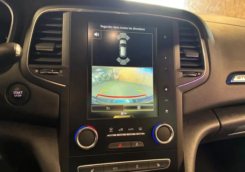 Vue rapprochée de la console centrale de la Renault Mégane GT Line 2019, écran tactile avec caméra de recul et commandes climatisation.