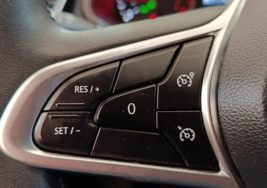 Gros plan sur les commandes du régulateur de vitesse au volant cuir synthétique de la Renault Clio Business Blue dCi 100.