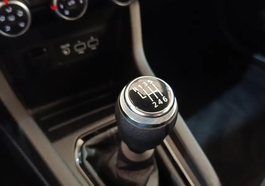 Gros plan sur le levier de vitesse manuel de la Renault Clio Business Blue dCi 100, intérieur noir avec ports USB visibles.