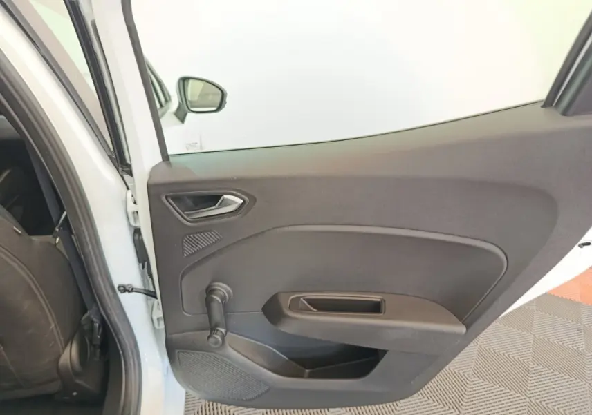 Vue intérieure sur la porte arrière gauche noire d'une Renault Clio Business Blue dCi 100 blanche, avec poignée manuelle.