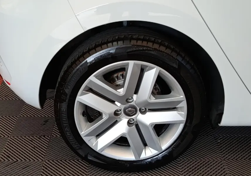 Gros plan sur la roue arrière droite d’une Renault Clio Business Blue dCi 100 blanche avec jante alliage argentée.