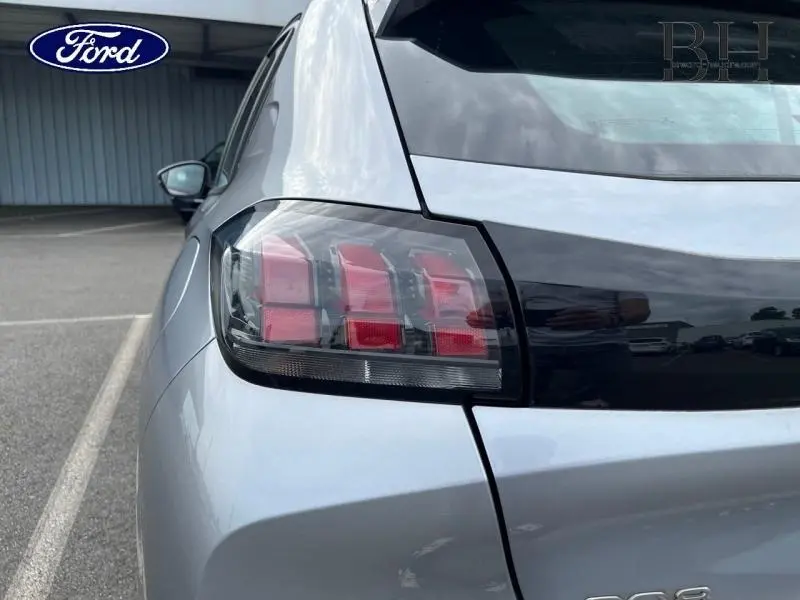 Gros plan sur le feu arrière gauche d'une Peugeot 208 gris Artense, soulignant la finition moderne et les lignes arrière du véhicule.