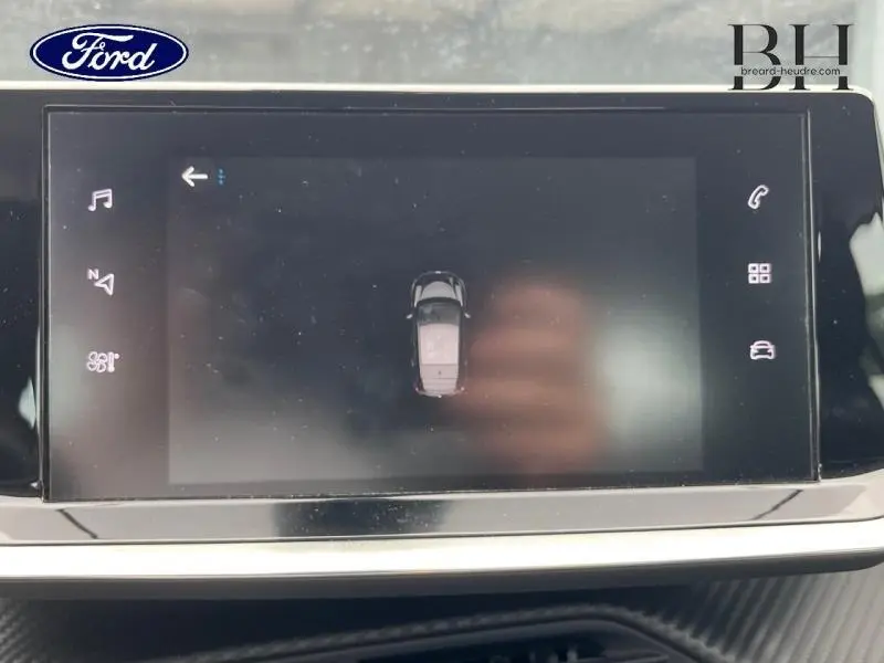 Écran tactile central de la Peugeot 208 gris Artense montrant une vue de dessus du véhicule en stationnement.