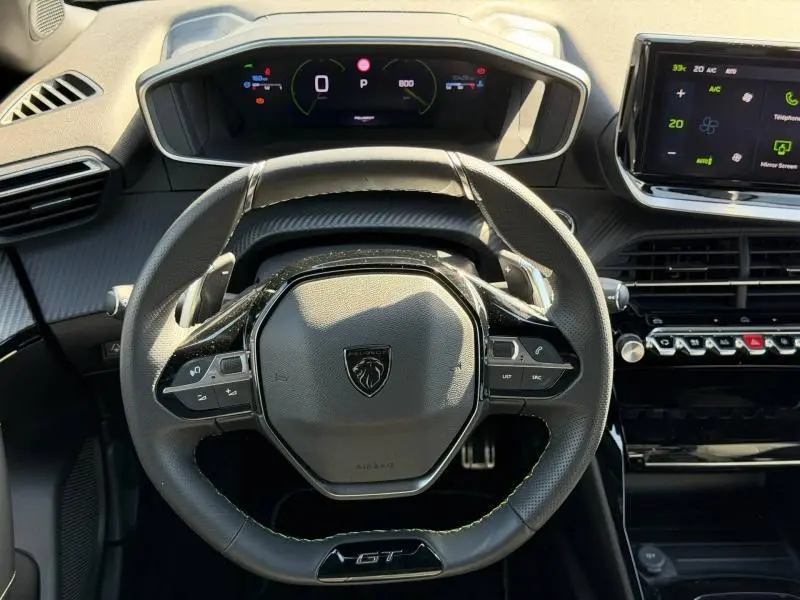 Vue rapprochée du volant cuir noir GT et du tableau de bord numérique du Peugeot 2008 gris 2024.