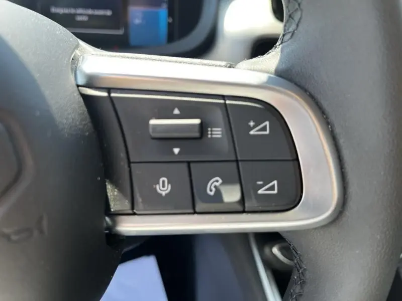 Gros plan sur les commandes multifonctions au volant du Jeep Avenger blanc électrique, version Altitude 2025.