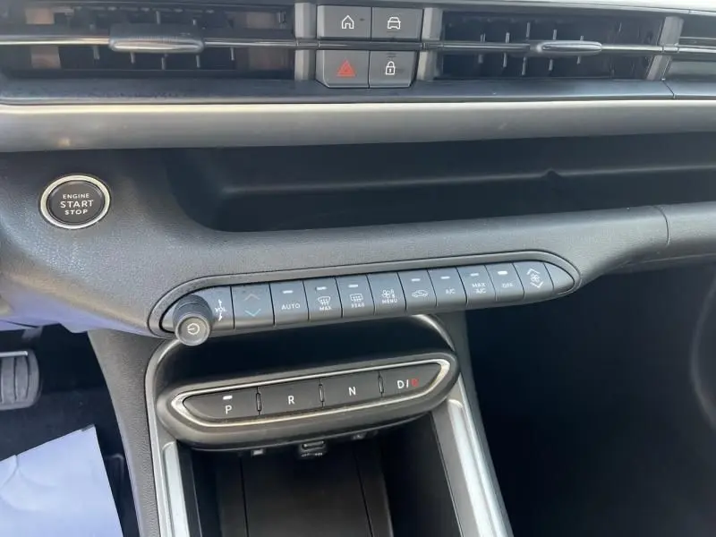 Vue rapprochée de la console centrale noire du Jeep Avenger 2025 avec boutons de climatisation et sélecteur de boîte auto.