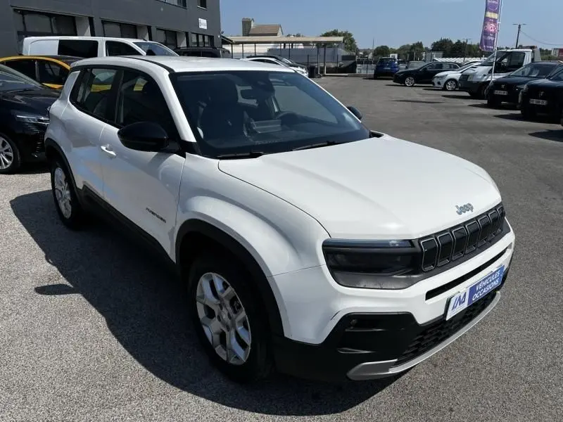 Jeep Avenger électrique blanc en 3/4 avant droit, avec calandre noire et détails noirs contrastants visibles.