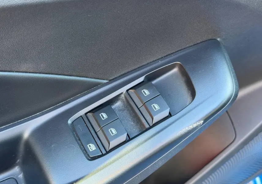 Gros plan sur les commandes des vitres électriques côté conducteur d'une MG3 1.5 Hybrid+ 2025 en Como Blue métallisé.