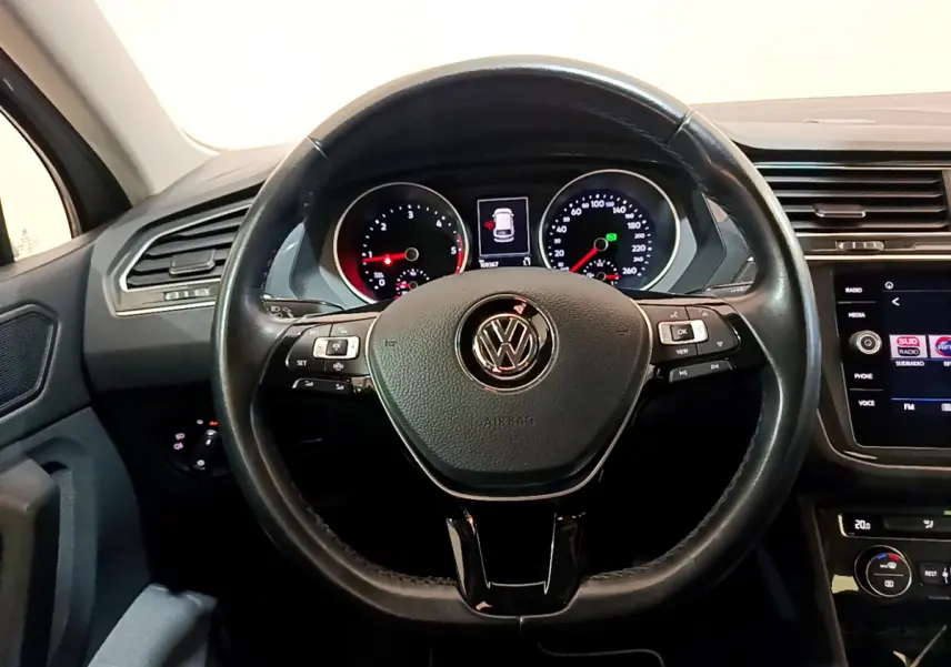 Vue rapprochée du volant cuir multifonctions et du tableau de bord numérique du Volkswagen Tiguan gris clair 2020.