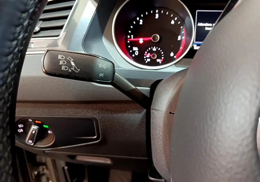 Gros plan sur la manette de clignotants et le tableau de bord noir du Volkswagen Tiguan 2.0 TDI 2020, côté gauche du volant.