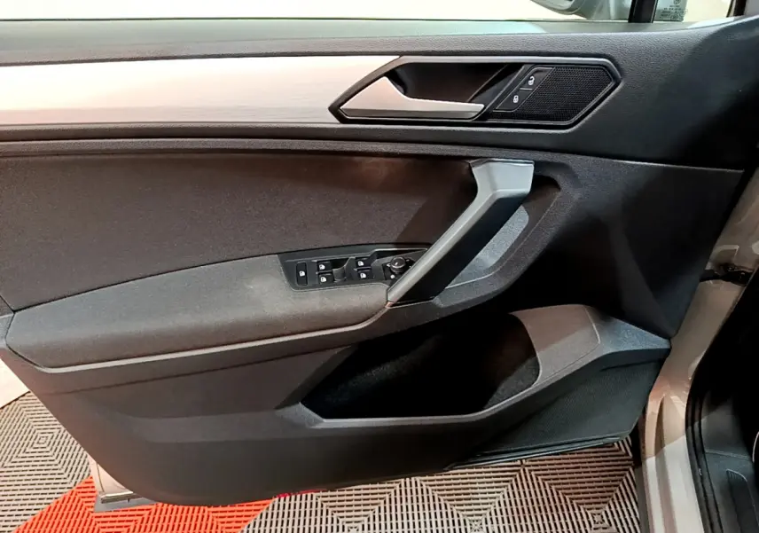 Porte côté conducteur du Volkswagen Tiguan gris clair 2020, avec commandes électriques et insert imitation bois.