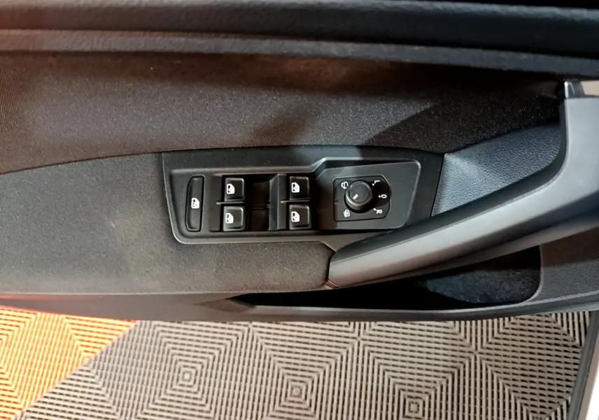 Panneau de commandes des vitres et rétroviseurs sur la porte côté gauche d'un Volkswagen Tiguan gris clair 2020.