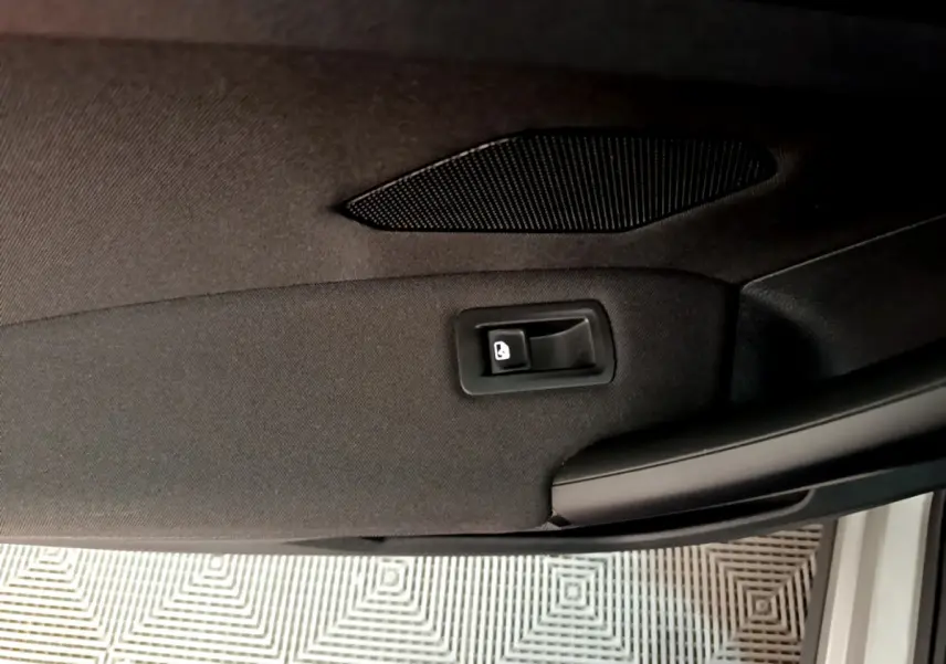 Détail de la poignée intérieure de porte arrière droite noire du Volkswagen Tiguan 2020 gris clair.