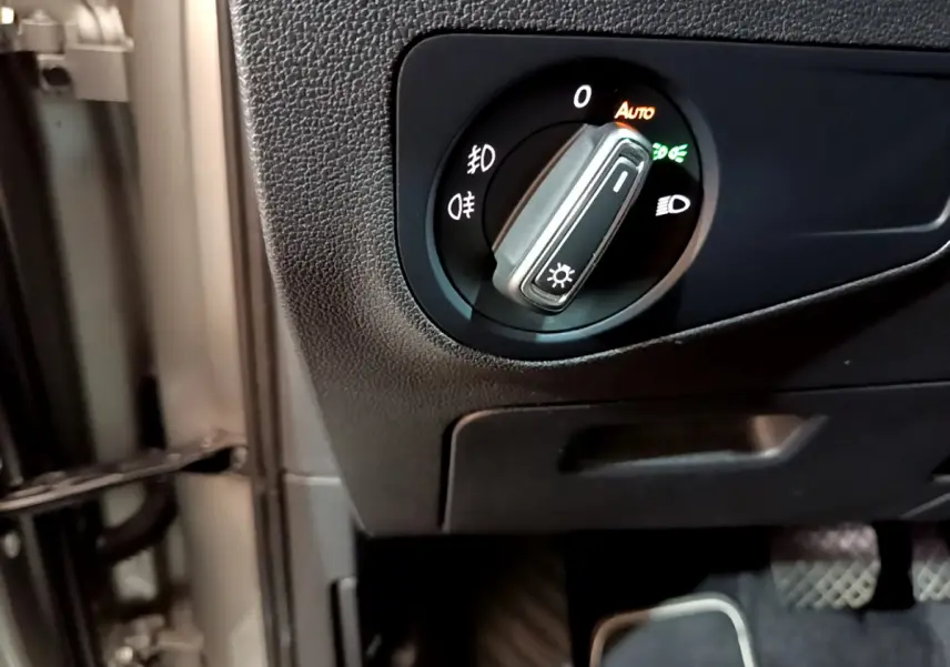 Gros plan sur le bouton de commande des phares à gauche du volant dans un Volkswagen Tiguan gris clair 2020