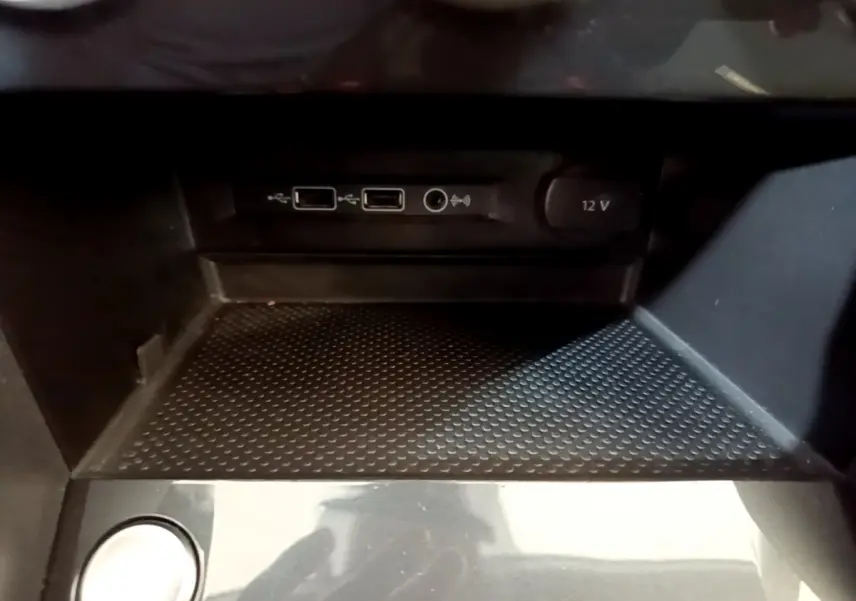 Gros plan sur la console centrale noire du Volkswagen Tiguan 2.0 TDI avec ports USB et prise 12V visibles