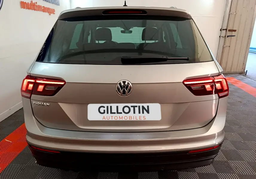 Vue arrière d'un Volkswagen Tiguan gris clair 2020 avec feux LED allumés et logo VW visible.