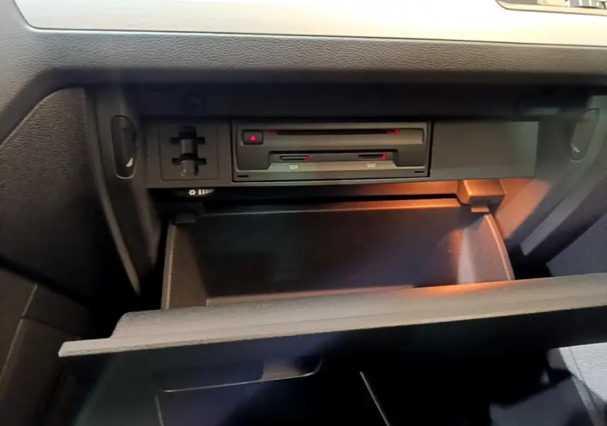 Gros plan sur la boîte à gants ouverte du Volkswagen Tiguan 2020 avec lecteur SD intégré et éclairage intérieur.