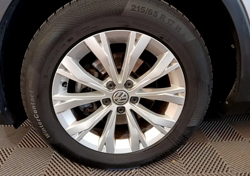 Gros plan sur la jante alliage argentée avec logo Volkswagen du Volkswagen Tiguan gris clair 2020.