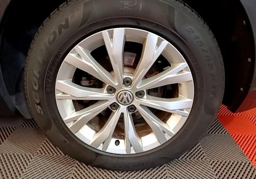 Gros plan sur la jante alliage argentée et pneu hiver Pirelli Scorpion du Volkswagen Tiguan gris clair.