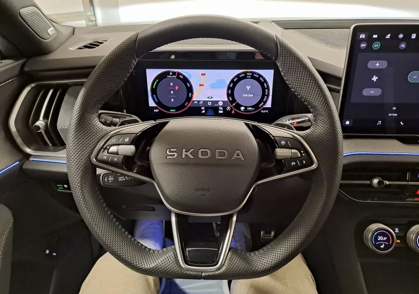 Vue intérieure centrée sur le volant SKODA du KODIAQ 2025 avec tableau de bord numérique et écran tactile.