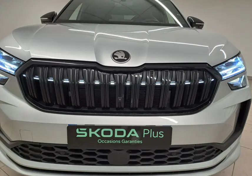 Vue avant rapprochée du Skoda Kodiaq gris argent avec calandre noire et phares LED allumés.