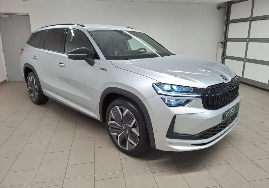 Vue 3/4 avant droite du Skoda Kodiaq gris argent 2025 avec calandre noire et jantes alliage 20 pouces design aérodynamique.