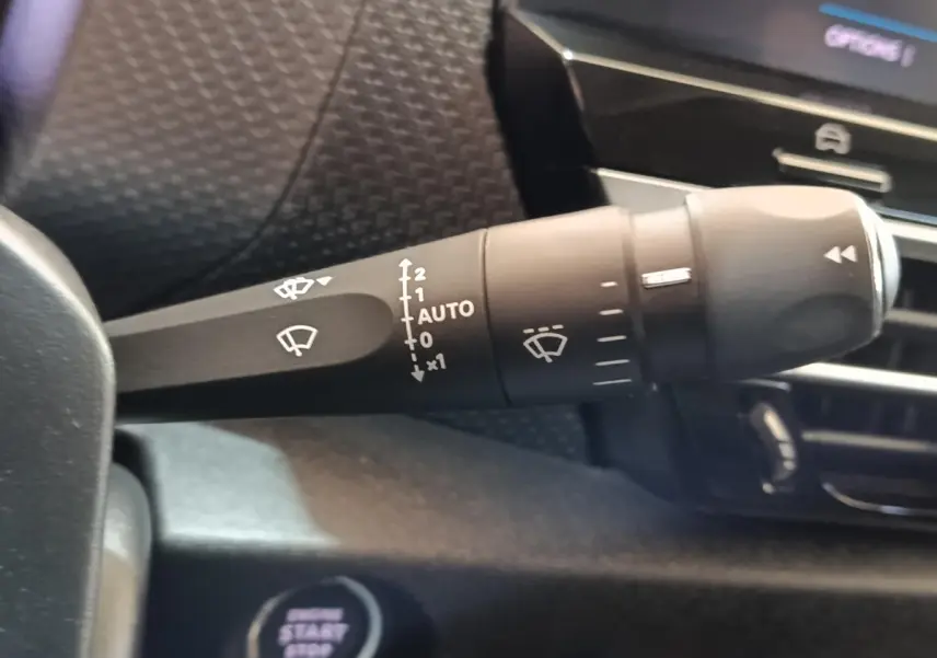 Gros plan sur la commande des essuie-glaces à gauche du volant dans l’habitacle gris foncé de la Citroën C4 2022.