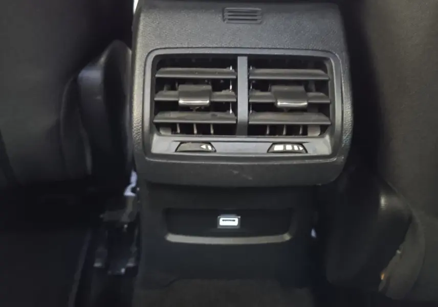 Vue rapprochée des aérateurs arrière noirs et port USB du Citroën C4 BlueHDi 130 gris foncé, intérieur arrière.