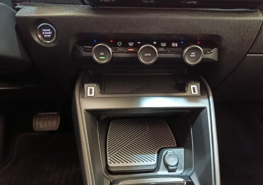 Vue rapprochée de la console centrale noire du Citroën C4 2022 avec commandes climatisation et bouton start/stop.
