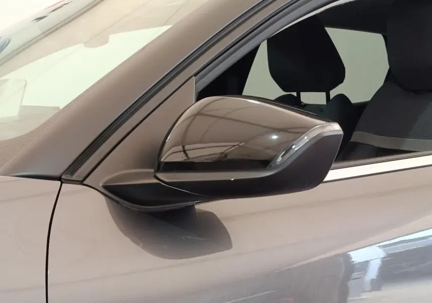 Rétroviseur côté gauche d'une Citroën C4 gris foncé 2022, avec partie de la portière et siège visible.