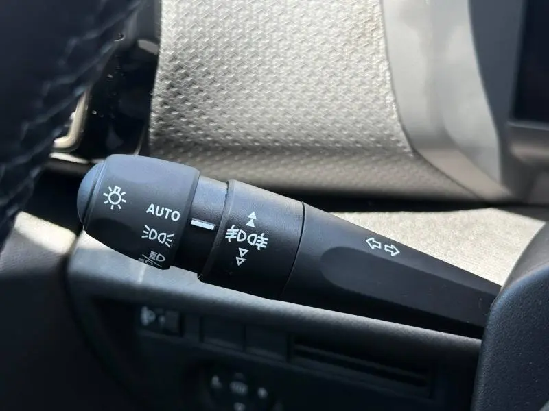 Gros plan sur la commande des feux et clignotants à gauche du volant dans l'habitacle d'une Citroën C4 gris Mercury.