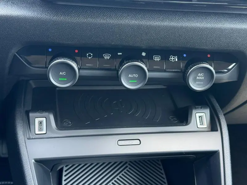 Vue rapprochée de la console centrale de la Citroën C4 2025, montrant les commandes de climatisation et ports USB.