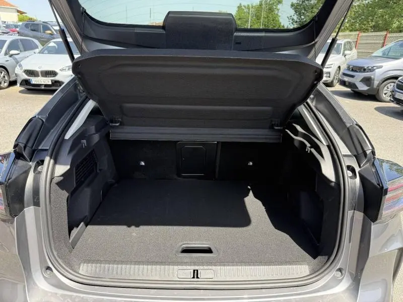 Coffre ouvert de la Citroën C4 gris Mercury, vue arrière, montrant l'espace de chargement et la plage arrière relevée.