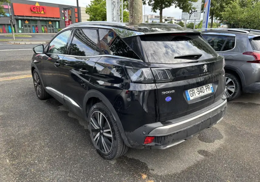 Peugeot 3008 noir métallisé vu en 3/4 arrière droit, avec jantes alliage 19 pouces et vitres surteintées.