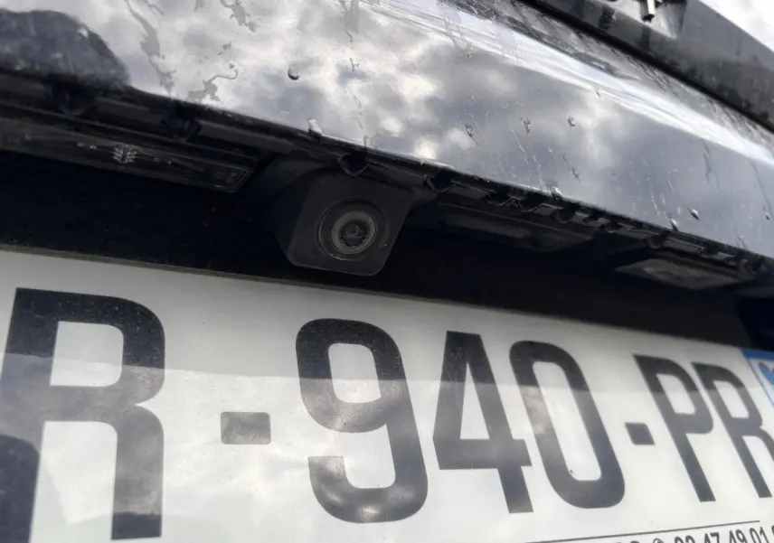 Gros plan sur la caméra de recul et la plaque d’immatriculation d’un Peugeot 3008 noir, arrière du véhicule.