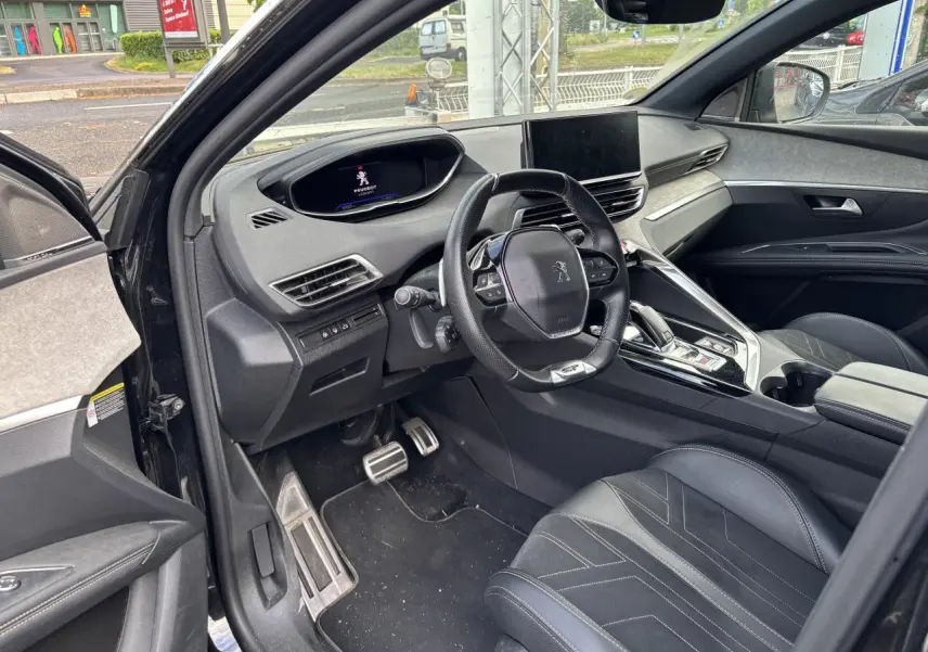 Vue intérieure côté conducteur du Peugeot 3008 noir 2022, mettant en valeur le tableau de bord digital et le volant compact multifonctions.
