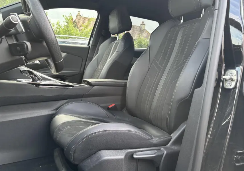 Vue intérieure côté conducteur du Peugeot 3008 noir, mettant en valeur le siège avant en cuir avec surpiqûres.