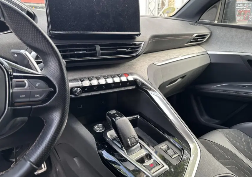 Vue intérieure côté conducteur du Peugeot 3008 GT Pack 2022, montrant la console centrale avec levier de vitesse et écran tactile.