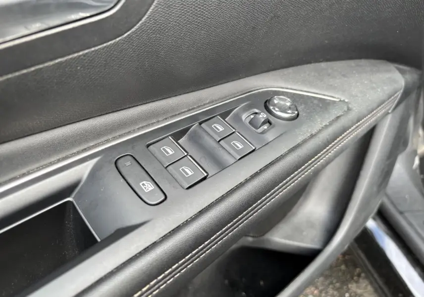 Gros plan sur la commande des lève-vitres et rétroviseurs côté conducteur du Peugeot 3008 noir, finition GT Pack.