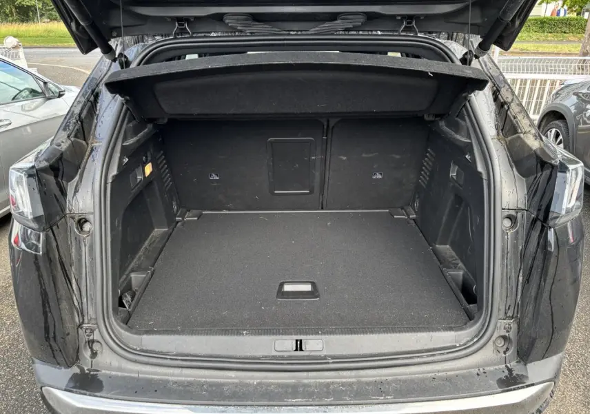 Coffre ouvert d'un Peugeot 3008 noir vu de l'arrière, montrant un espace de chargement spacieux et propre.