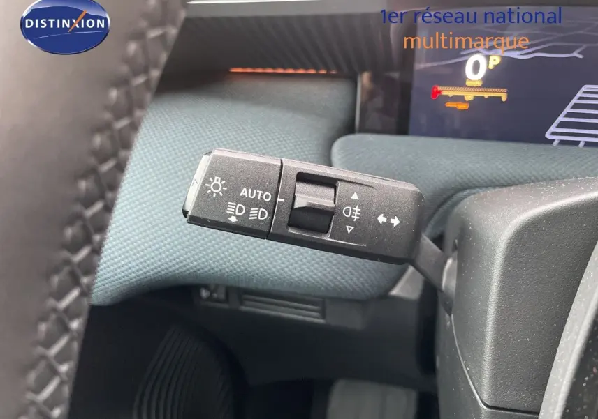 Gros plan sur la commande des feux automatique à gauche du volant dans l’habitacle du Citroën C5 Aircross gris platinium.