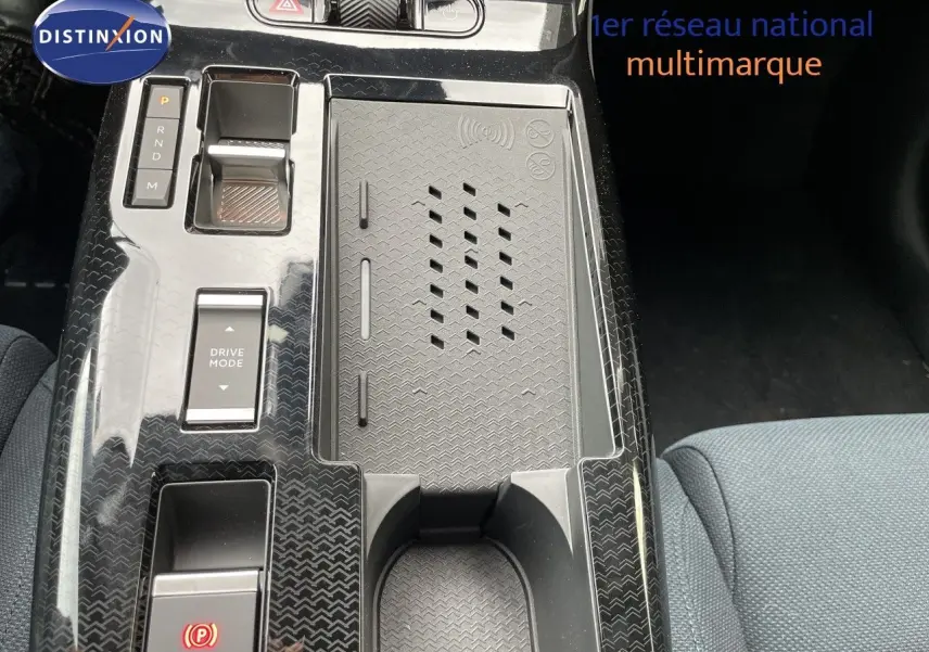 Vue rapprochée de la console centrale noire brillante du Citroën C5 Aircross Hybrid 145ch avec commandes de boîte auto et espace de rangement.