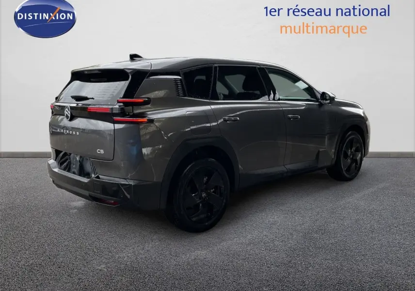 Vue 3/4 arrière droite d'un Citroën C5 Aircross gris platinium métallisé avec jantes noires et feux arrière LED horizontaux.