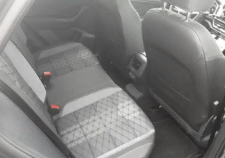 Vue intérieure du siège arrière droit du Volkswagen T-Roc 2025 avec sellerie tissu gris à motifs géométriques.