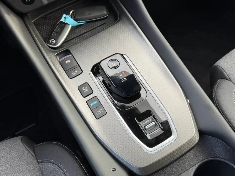 Vue rapprochée de la console centrale noire du Nissan Qashqai Hybrid e-POWER 2025 avec sélecteur de boîte auto et clés.